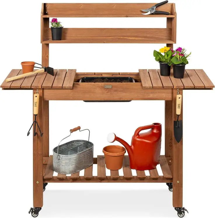 A wooden potting bench with tools on it.